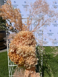 a bunch of flowers in a basket on a grassy area