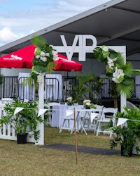 a white tent with a red umbrella